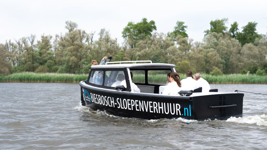 Sloep gehuurd door gezelschap die vaart door de Biesbosch